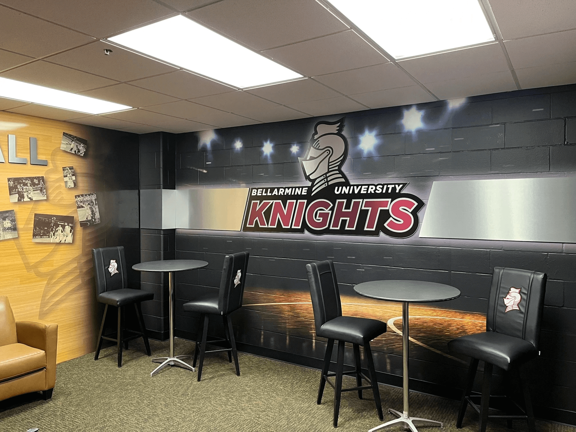 A lounge area representing Bellarmine University Knights, featuring a thematic wall with the school's logo and the text 