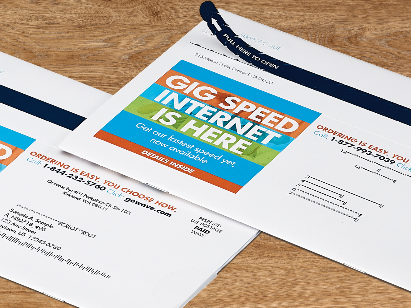 Two promotional internet service envelopes on a wooden table, featuring bold text on the main envelope advertising gig speed internet.