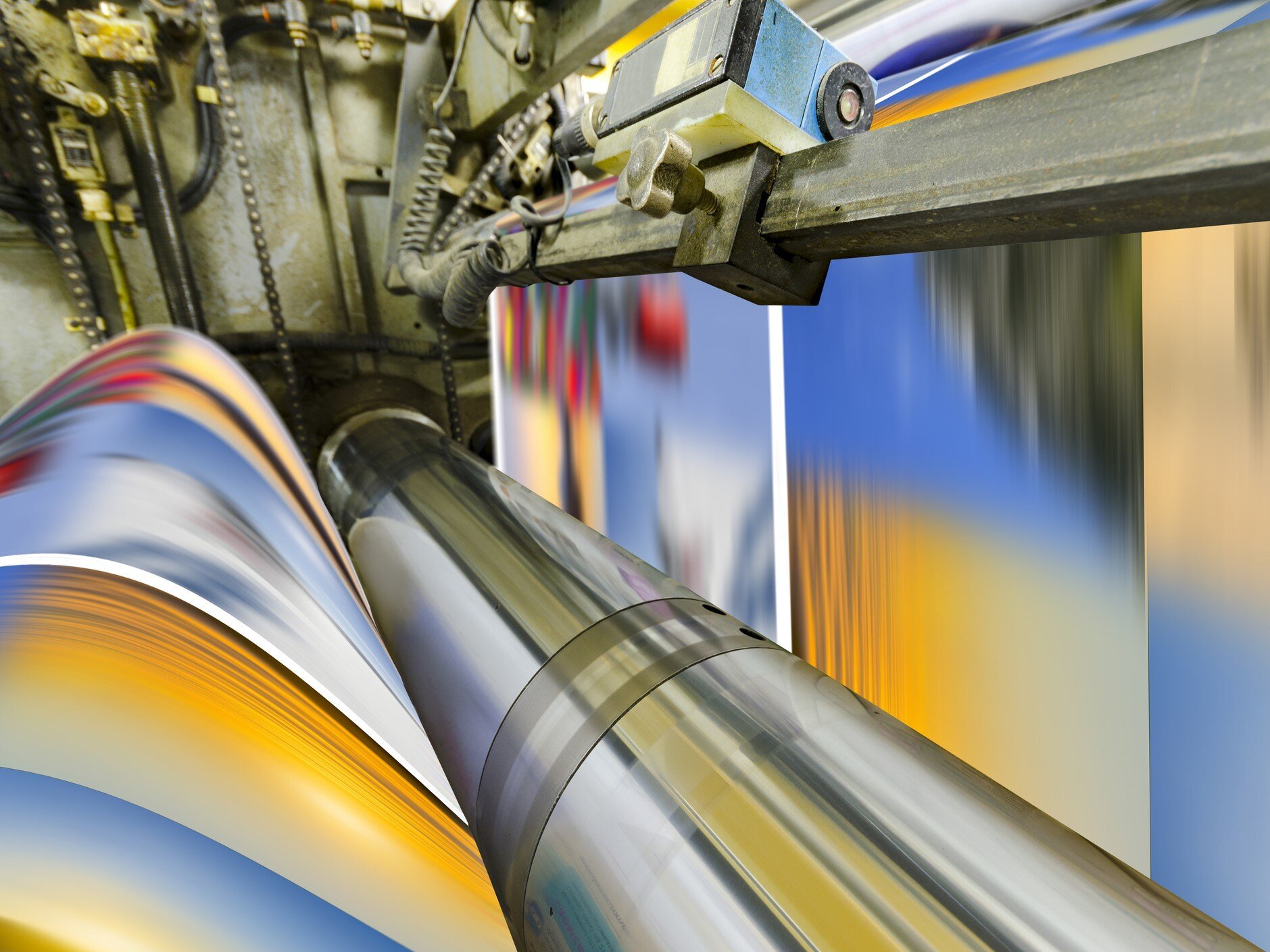 Close-up of a printing machine with colorful blurred material.